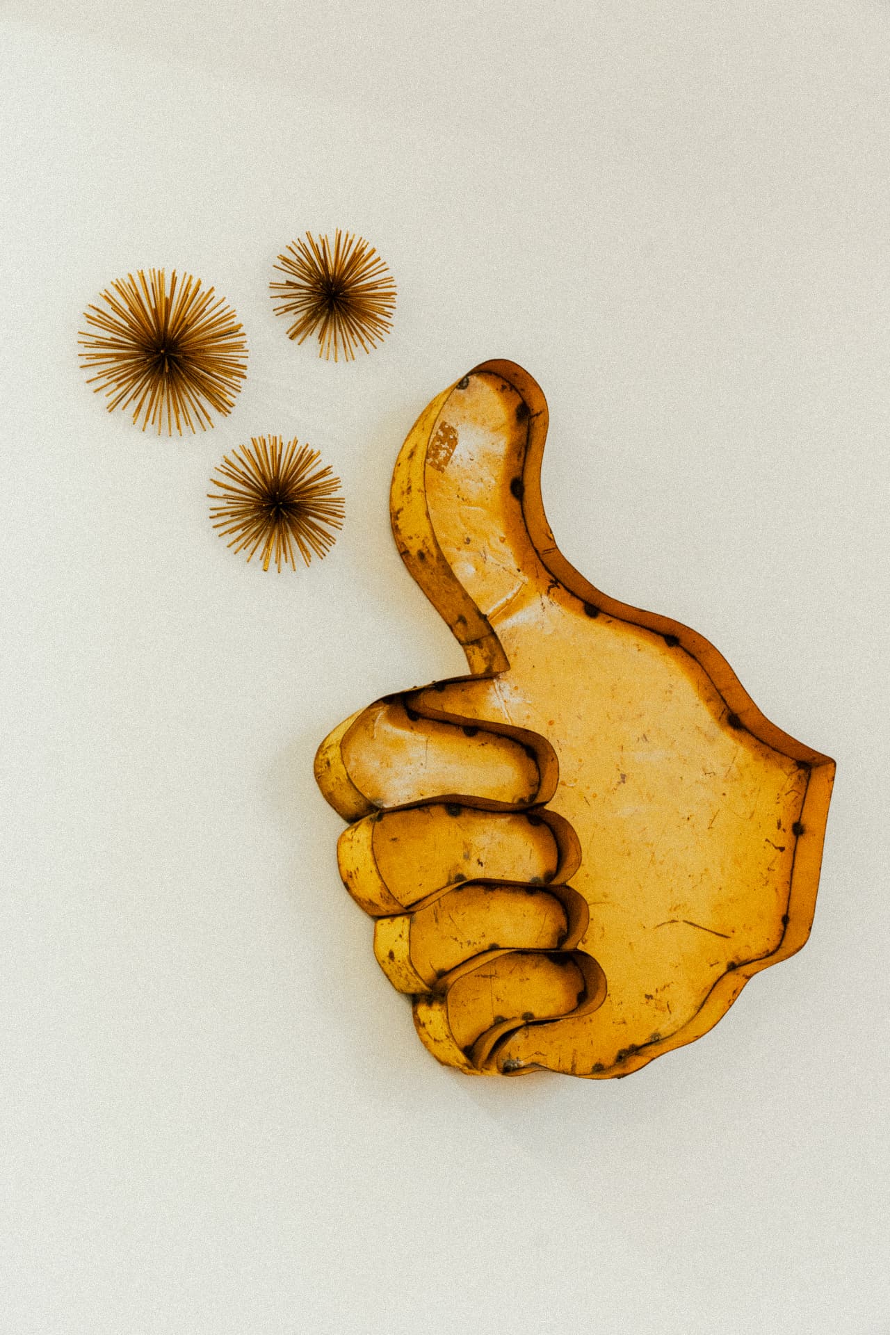 Vintage brass thumbs-up sculpture on the wall at Recovery Republic, Venice