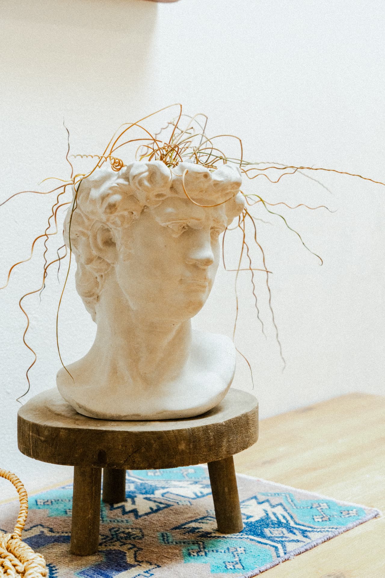 Plaster bust planter on a wooden stool at Recovery Republic men's treatment center