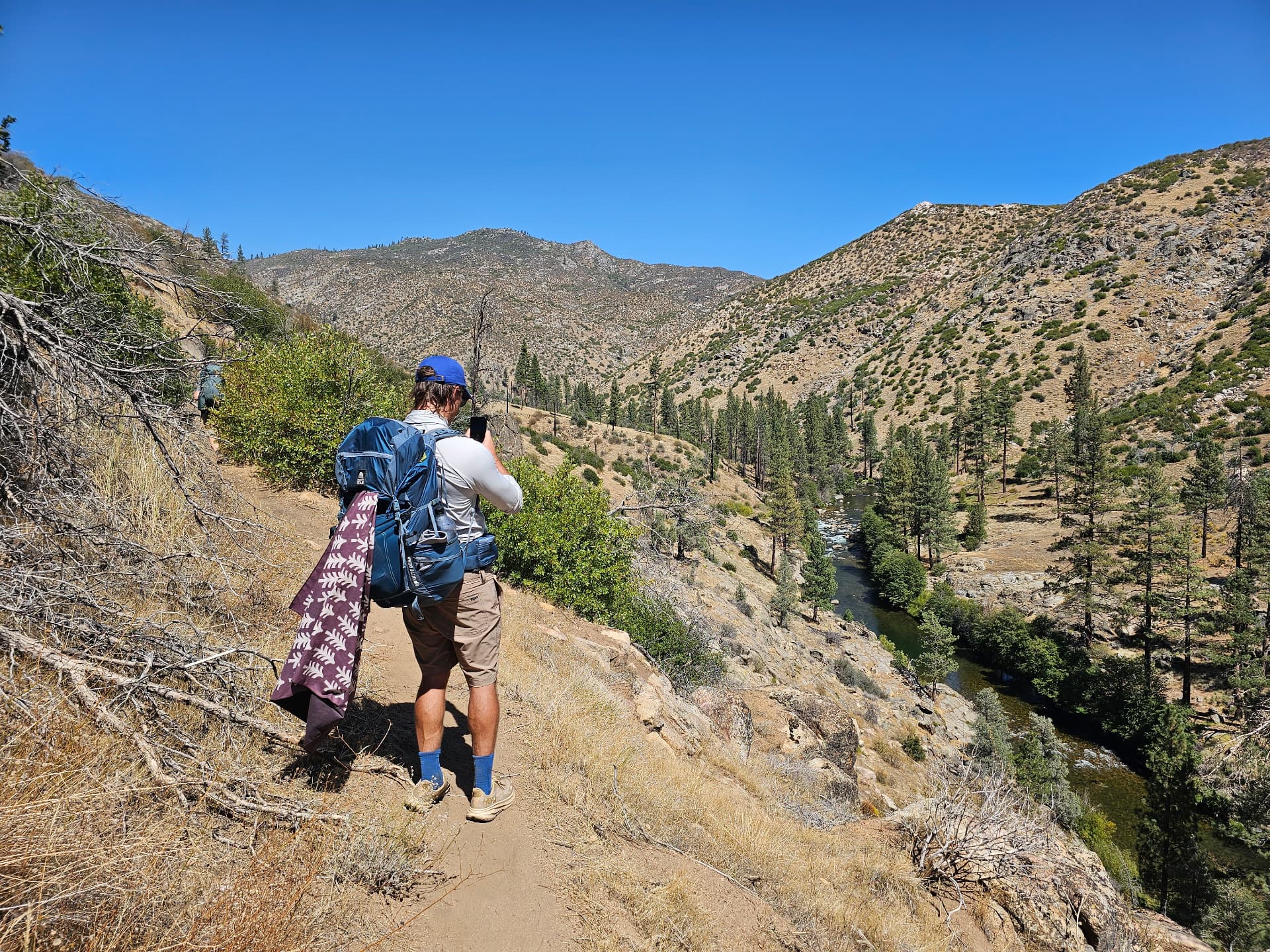 Backpacker looking out over the river canyon during a Recovery Republic wilderness therapy trip in Sequoia National Forest