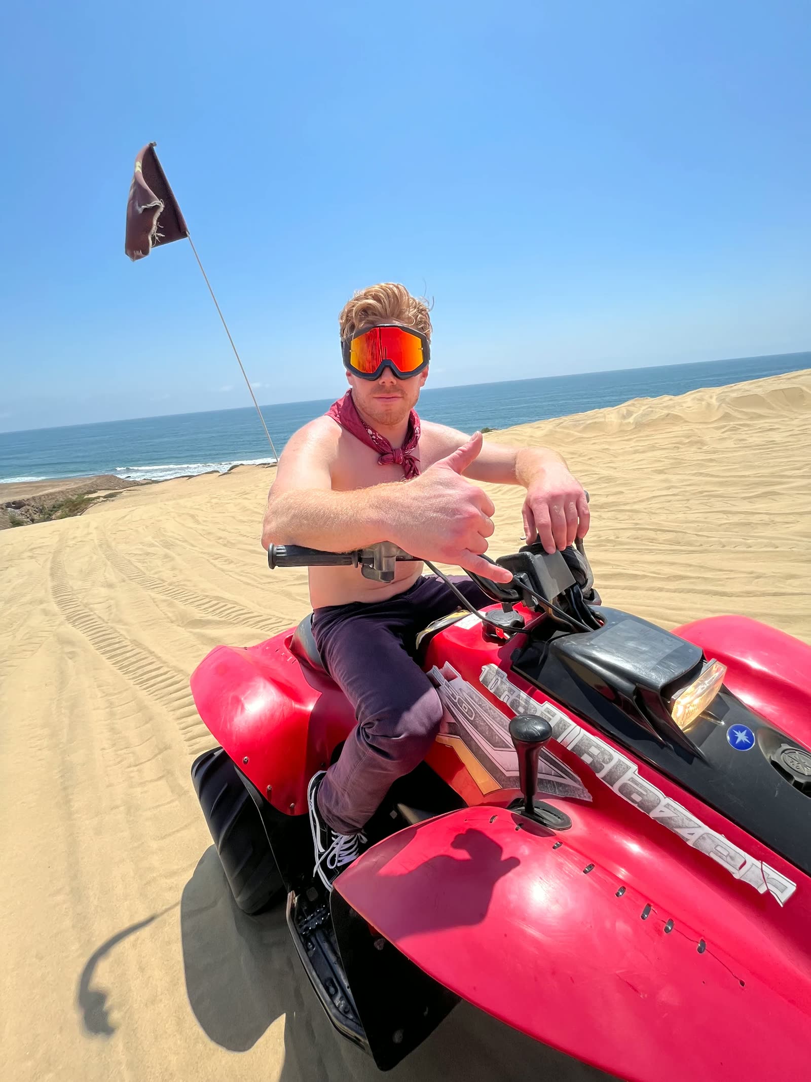Thumbs up on a quad at the edge of the Baja dunes above the ocean