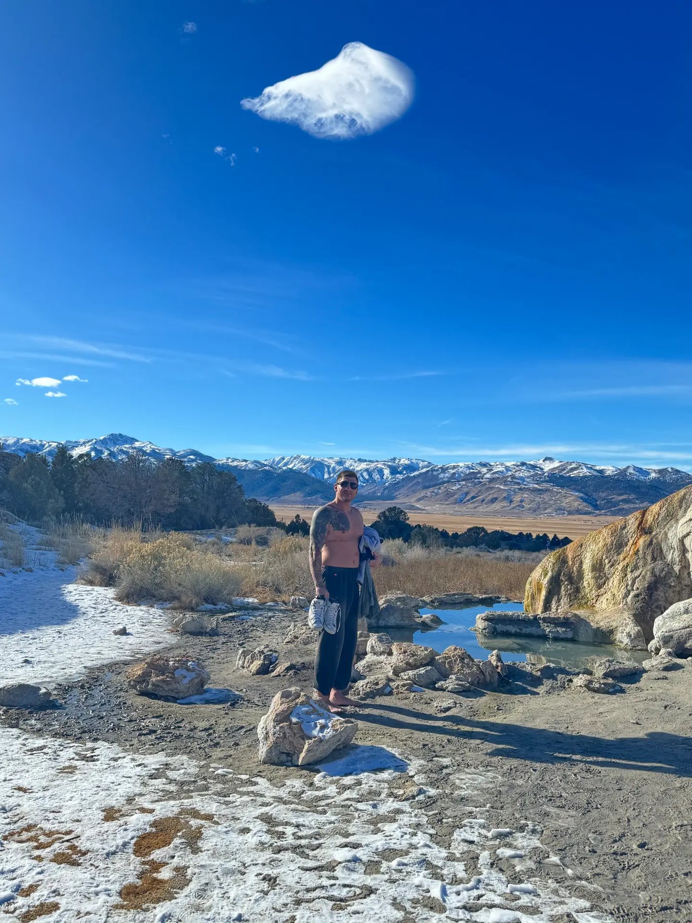 Standing barefoot at the roadside hot springs with Sierra peaks behind during outdoor therapy