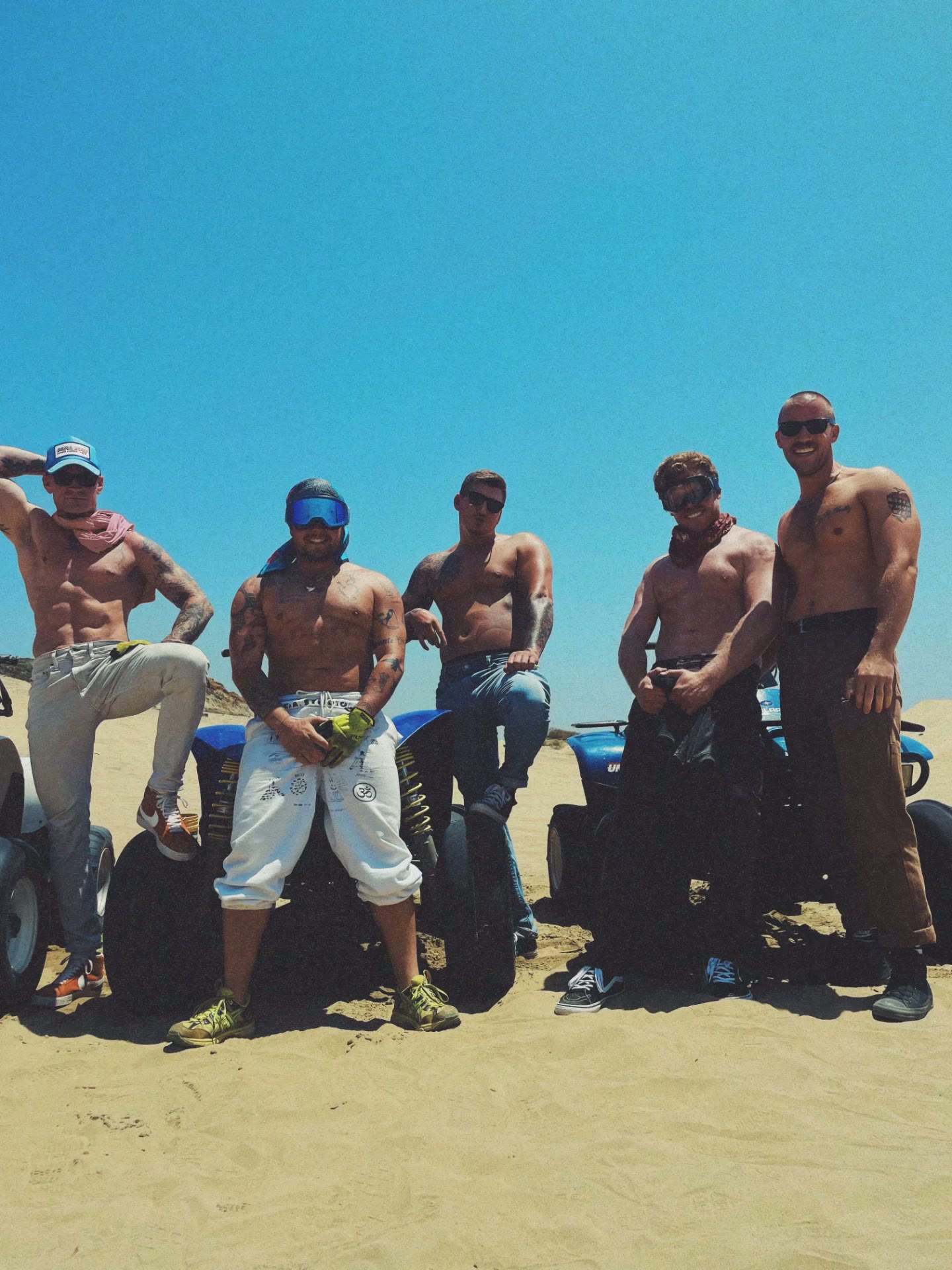 Men's outdoor therapy group posted up on ATVs in the Baja dunes