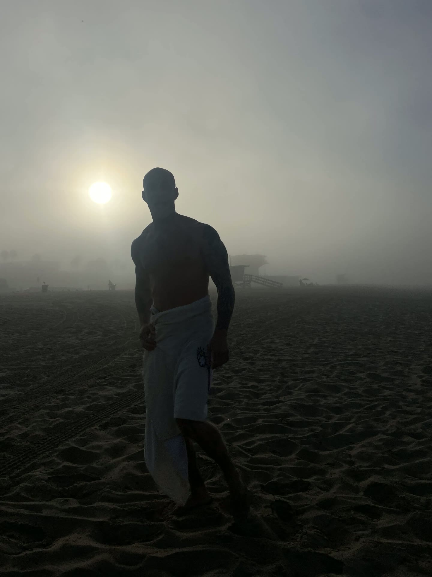 Sun burning through morning fog on the sand during a men's wilderness therapy trip