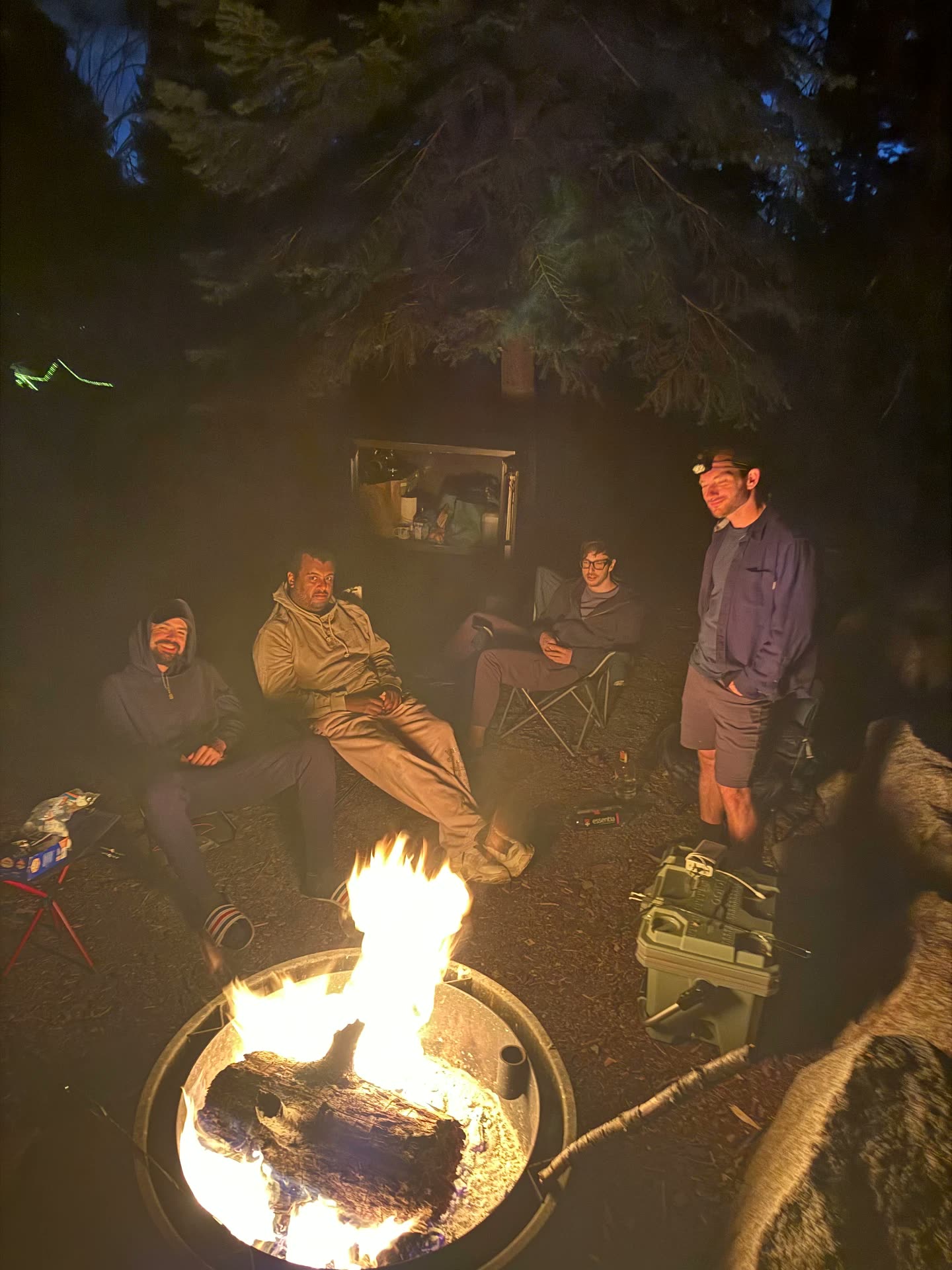 Men sitting around the fire pit at night talking during a Recovery Republic wilderness trip