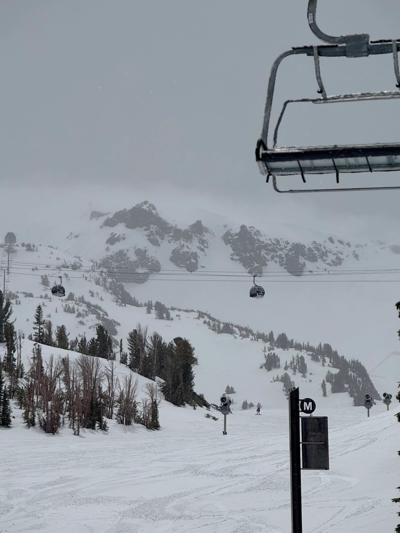 Gondolas running through the storm on a grey mountain morning at Mammoth