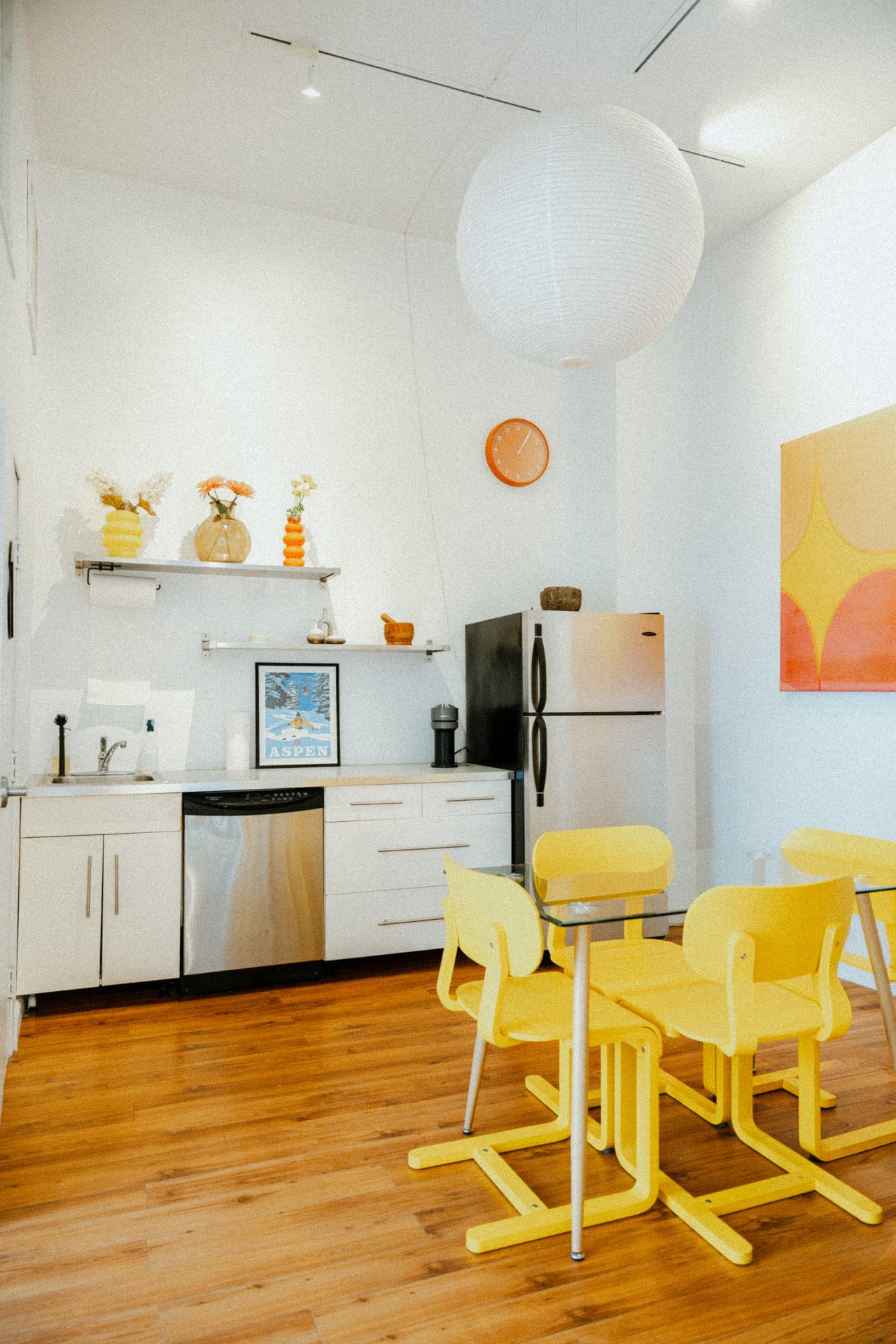 Kitchen shelves with flowers and an orange clock at Recovery Republic, Venice