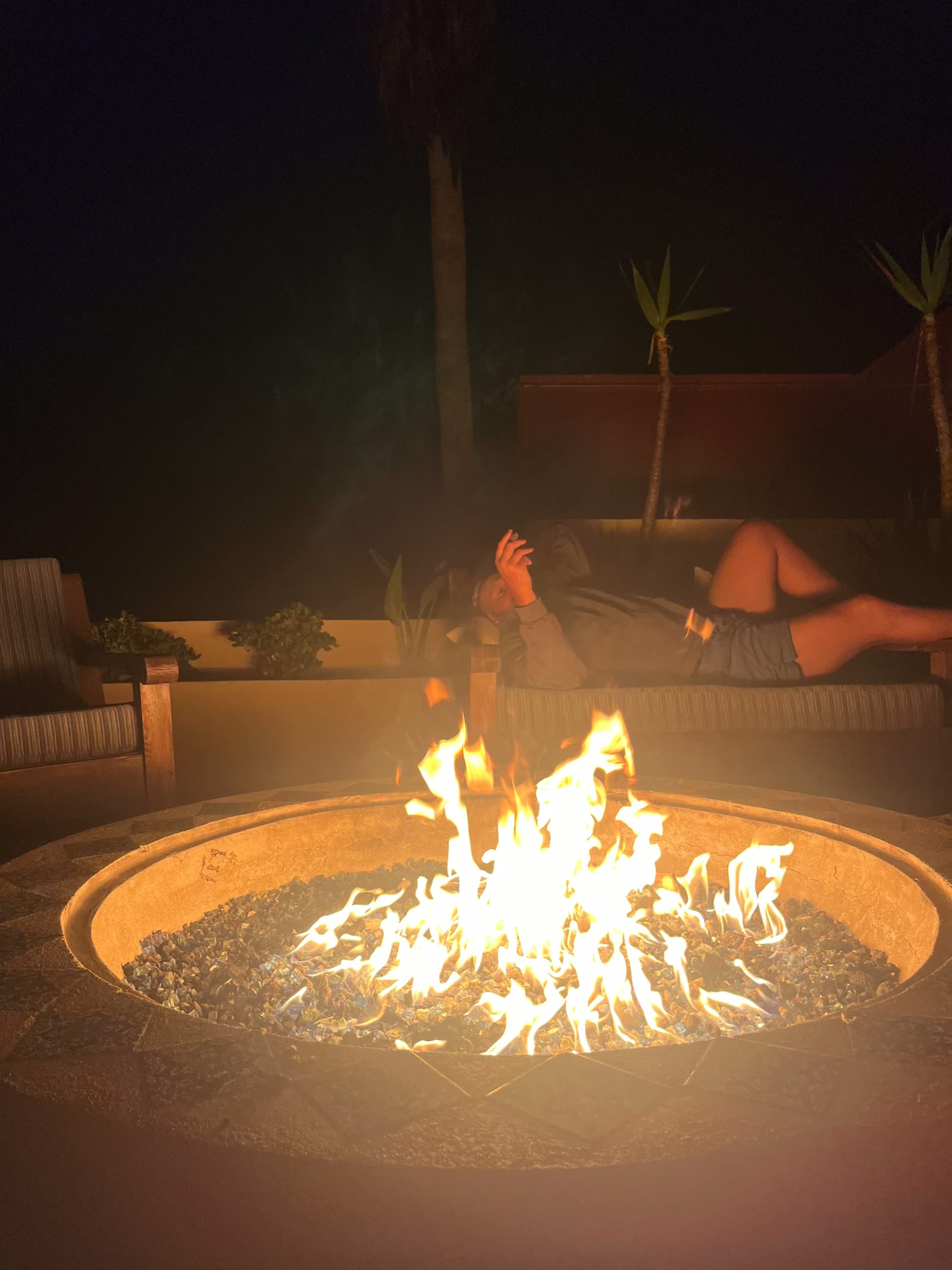Men laid out by the fire pit after dark during a wilderness therapy trip
